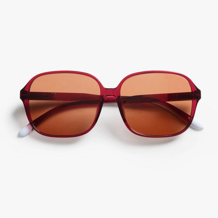 Sunglasses with red frame and brown lenses on a white background