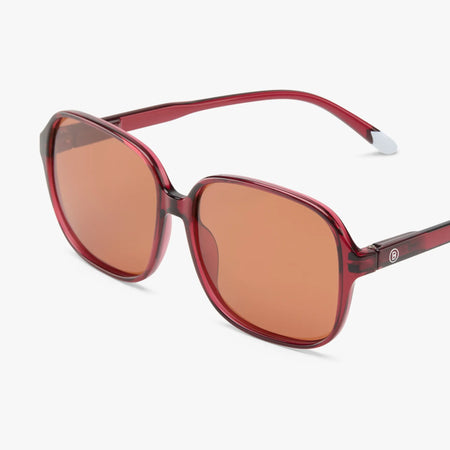 Red sunglasses with brown lenses on a white background