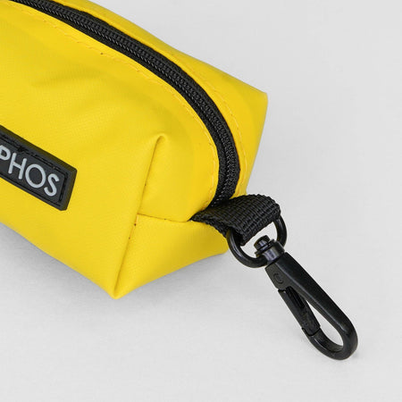 Yellow bag dispenser with black zipper and carabiner on a light gray background