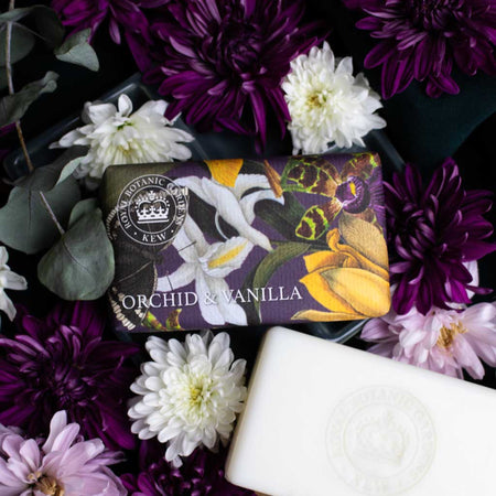 Soap bar with 'Orchid & Vanilla' scent wrapped in orchid illustrations from the Kew archives and surrounded by flowers