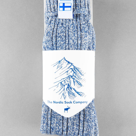 Baltic blue knitted Sisu of Finland socks with a Finnish flag brand label on a gray background. Lambswool and cotton rich to get you through the cold Arctic nights.