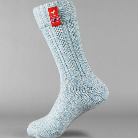 Pale blue knitted Norwegian Fjord socks with a Norwegian flag brand label on a gray background. Lambswool and cotton rich to get you through the cold Arctic nights.