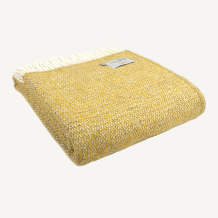Folded yellow and grey woollen illusion patterned throw with cream fringe on a white background