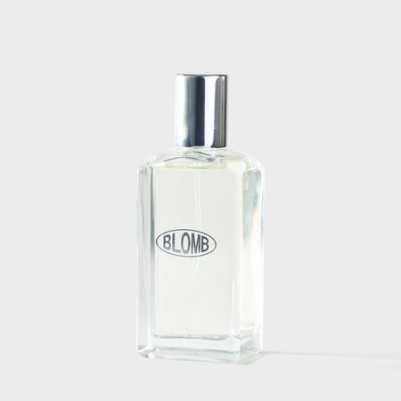 Clear glass bottle with silver cap on a white background, featuring the brand 'BLOMB'.