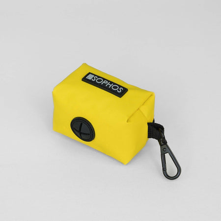 Yellow beg dispenser with a black carabiner on a light gray background