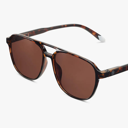 Sunglasses with tortoiseshell frame and brown lenses on a white background
