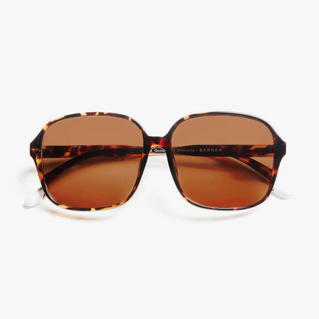 Oversized sunglasses with tortoiseshell frame and brown lenses on a white background