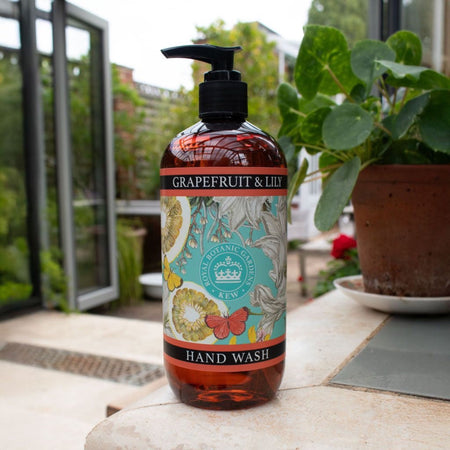 Grapefruit & Lily hand wash bottle with Kew Gardens logo and archival labels on a stone surface with a garden background