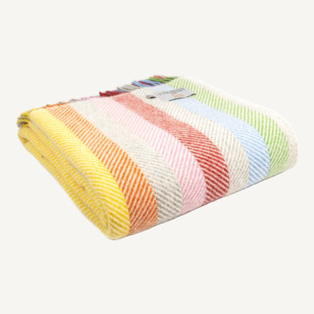 Folded pure new wool rainbow striped throw on a white background