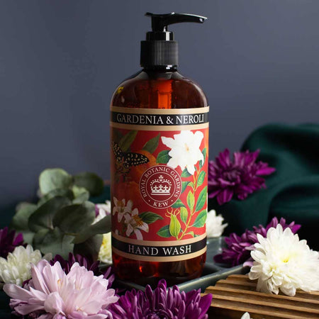 Hand wash bottle archival Kew Gardens illustration floral label photographed with flowers and greenery on a dark background