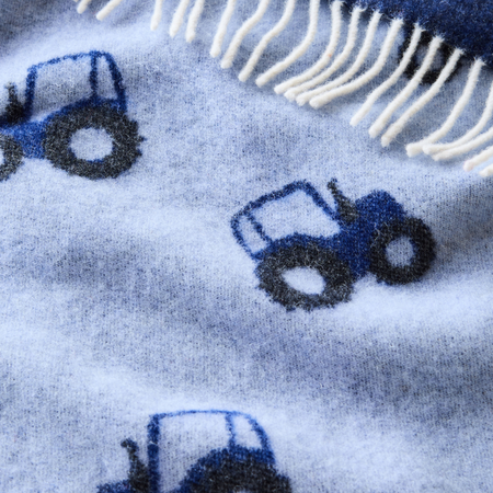 Close-up of a blue merino wool blanket with blue tractor patterns