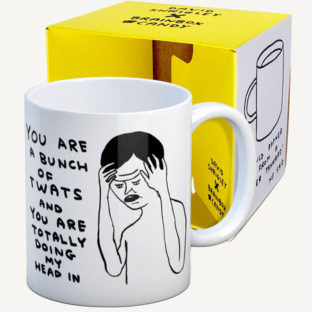 Mug with graphic design and text in front of a yellow and white box