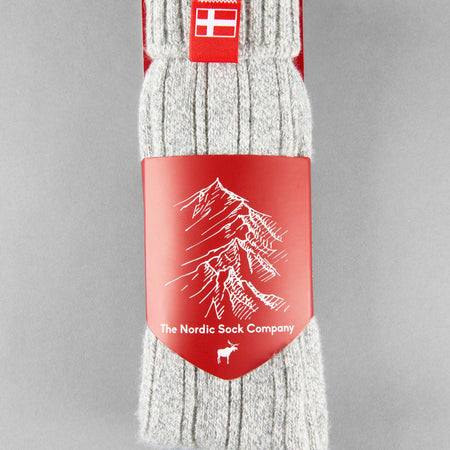 Sky grey knitted Danish Hygge socks with a Danish flag brand label on a gray background. Lambswool and cotton rich to get you through the cold Arctic nights.