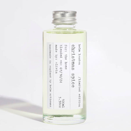 Bottle of Christmas Spice fragrance with a silver cap on a white background
