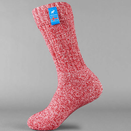 Red knitted Icelandic Saga socks with an Iceland flag brand label on a gray background. Lambswool and cotton rich to get you through the cold Arctic nights.