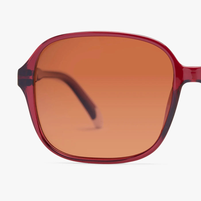Sunglasses with red frame and brown lens on a white background