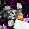 Soap bar with 'Orchid & Vanilla' scent wrapped in orchid illustrations from the Kew archives and surrounded by flowers