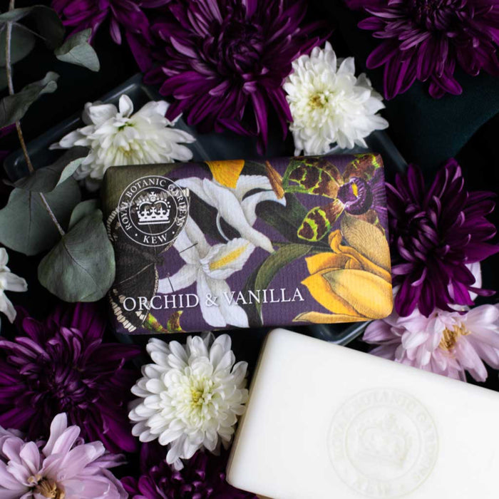 Soap bar with 'Orchid & Vanilla' scent wrapped in orchid illustrations from the Kew archives and surrounded by flowers