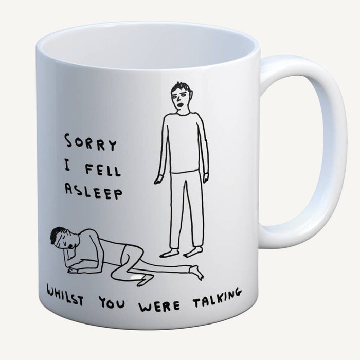 White mug with black illustrations and text on a white background. The text says, sorry I fell asleep whilst you were talking.