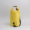 Yellow dry bag with a black strap on a light gray background