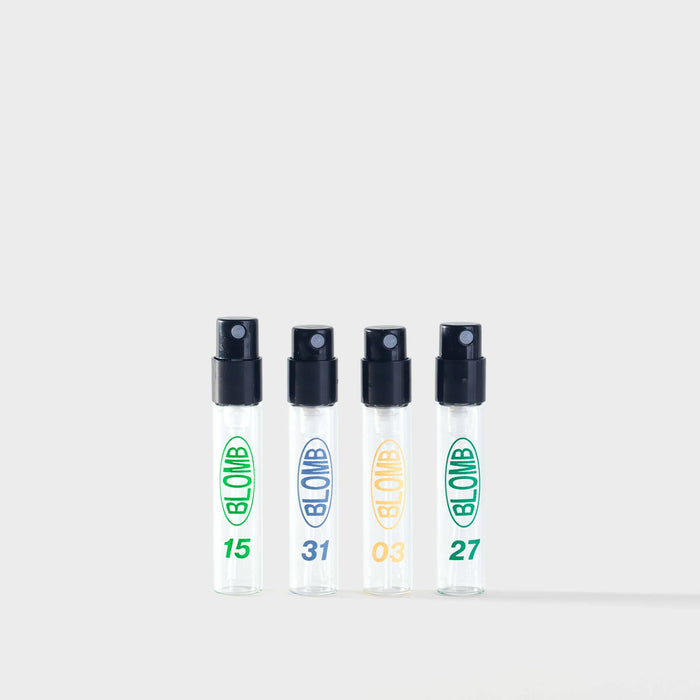 Four transparent spray bottles with black nozzles, Blomb logo and visible numbers on a white background