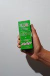 Hand holding a branded number 11 green box labeled 'BLOMB' against a plain background