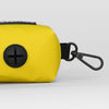 Yellow bag dispenser with black carabiner on a light gray background