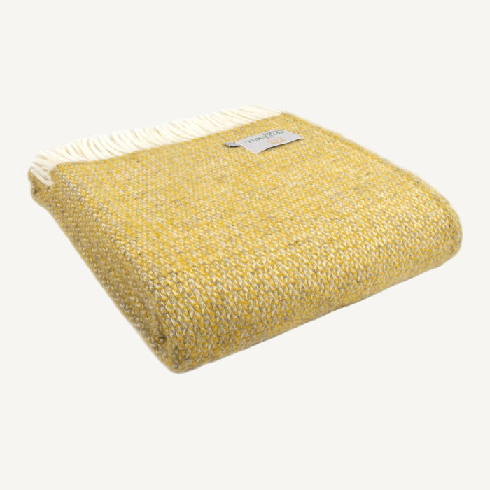 Folded yellow and grey woollen illusion patterned throw with cream fringe on a white background