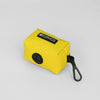Yellow beg dispenser with a black carabiner on a light gray background