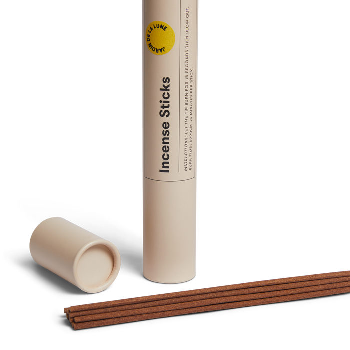 Incense sticks with a cylindrical Earl of East container on a white background