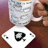 White mug with black tea illustrations and text, held over a coaster with a black and white design.
