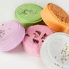 A mix of colourful shower steamers with visible textures and toppings on a white background