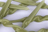A jumble of leaf green twisted taper candles on a white background