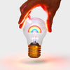 Rechargeable rainbow light is glowing in six different colours and held by a person's hand.