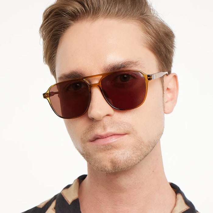 Man wearing a pair of sunglasses with a neutral background