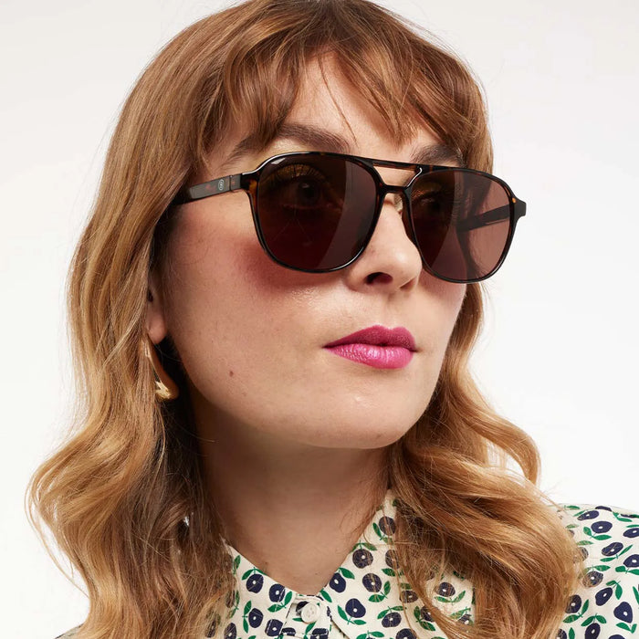 Woman wearing sunglasses with a neutral background