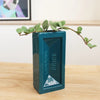 Teal brick-shaped vase with 'London Brick' branding on a wooden surface