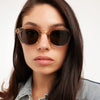 Woman wearing sunglasses with a neutral background