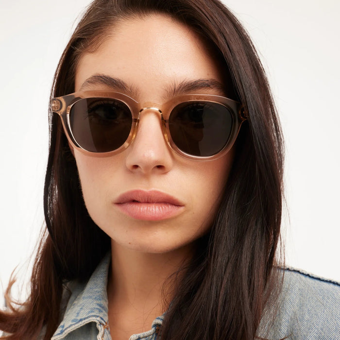 Woman wearing sunglasses with a neutral background