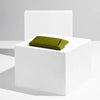 Green glasses case on a white pedestal against a gray background