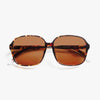 Oversized sunglasses with tortoiseshell frame and brown lenses on a white background