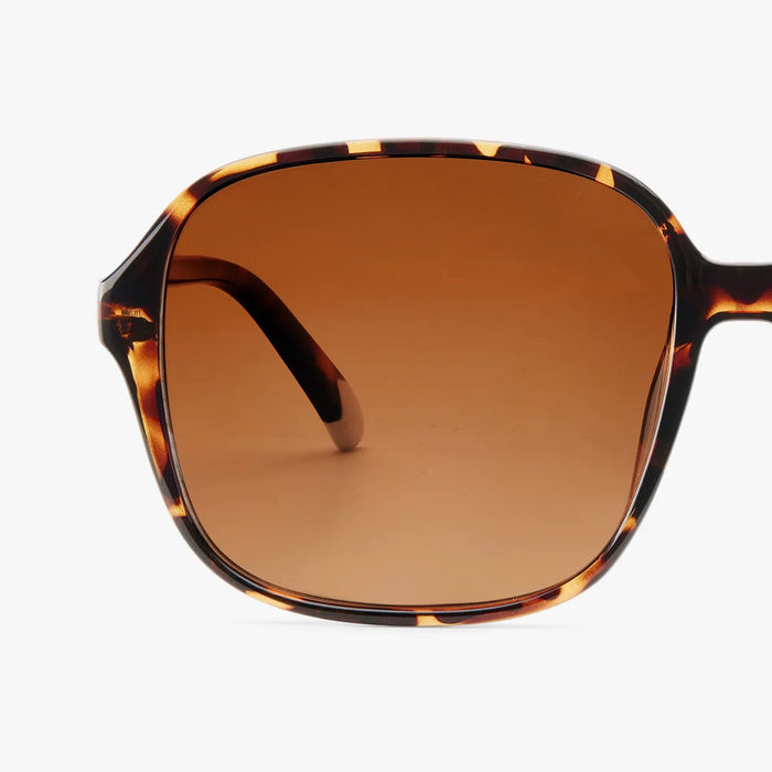 Sunglasses with tortoiseshell frame and brown gradient lens on a white background