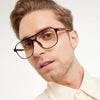 Man wearing tortoiseshell glasses on a white background