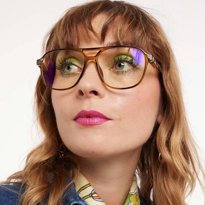 Close-up of a person wearing glasses with a neutral background