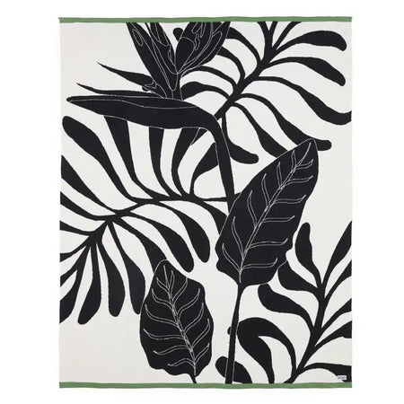 Cotton throw with black leaf pattern on an ivory background with narrow green stripe edge at both ends.