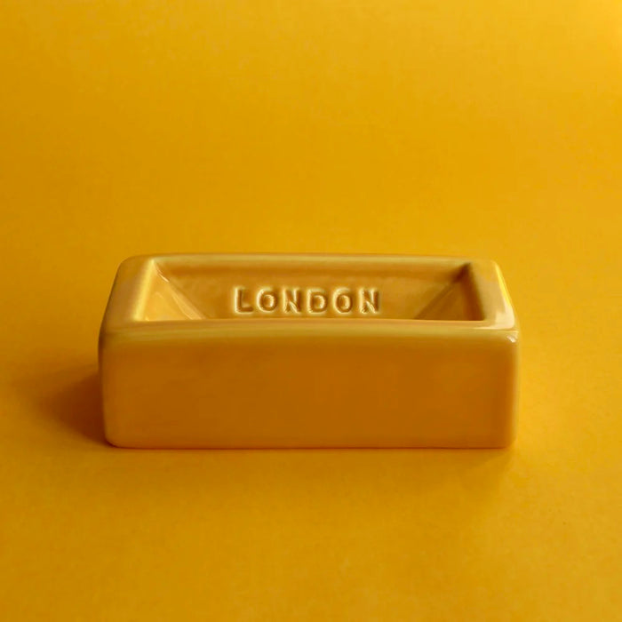Rectangular ceramic soap dish with 'London Brick' engraving on a yellow background