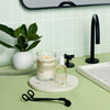 Bathroom counter with Malin+Goetz products, candle, and plant.