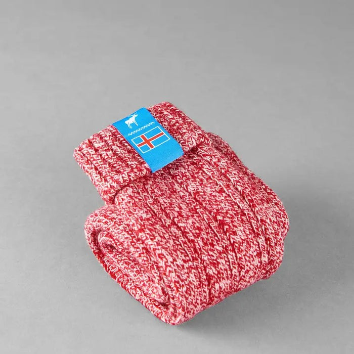 Folded red knitted Icelandic Saga socks with an Iceland flag brand label on a gray background. Lambswool and cotton rich to get you through the cold Arctic nights.