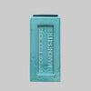 Turquoise brick-shaped vase with 'Outwood Brick Works Manchester' text on a gray background.Perfect for design lovers who appreciate function with an industrial edge.