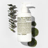 Malin+Goetz eucalyptus hand and body wash bottle with eucalyptus leaves on a white background